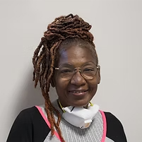 patient_woman02b Smiling patient wearing glasses and a dental bib, appearing satisfied after treatment.